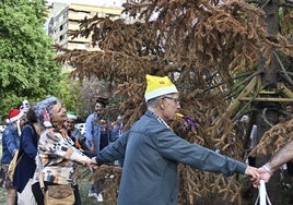 Celebración anticipada de las Navides de los vecinos de San Marcelino, con el abeto trasplantado ya muerto.