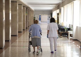 Una anciana junto a una trabajadora de una residencia.