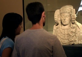 Dos personas observando la Dama de Elche en una imagen de archivo.