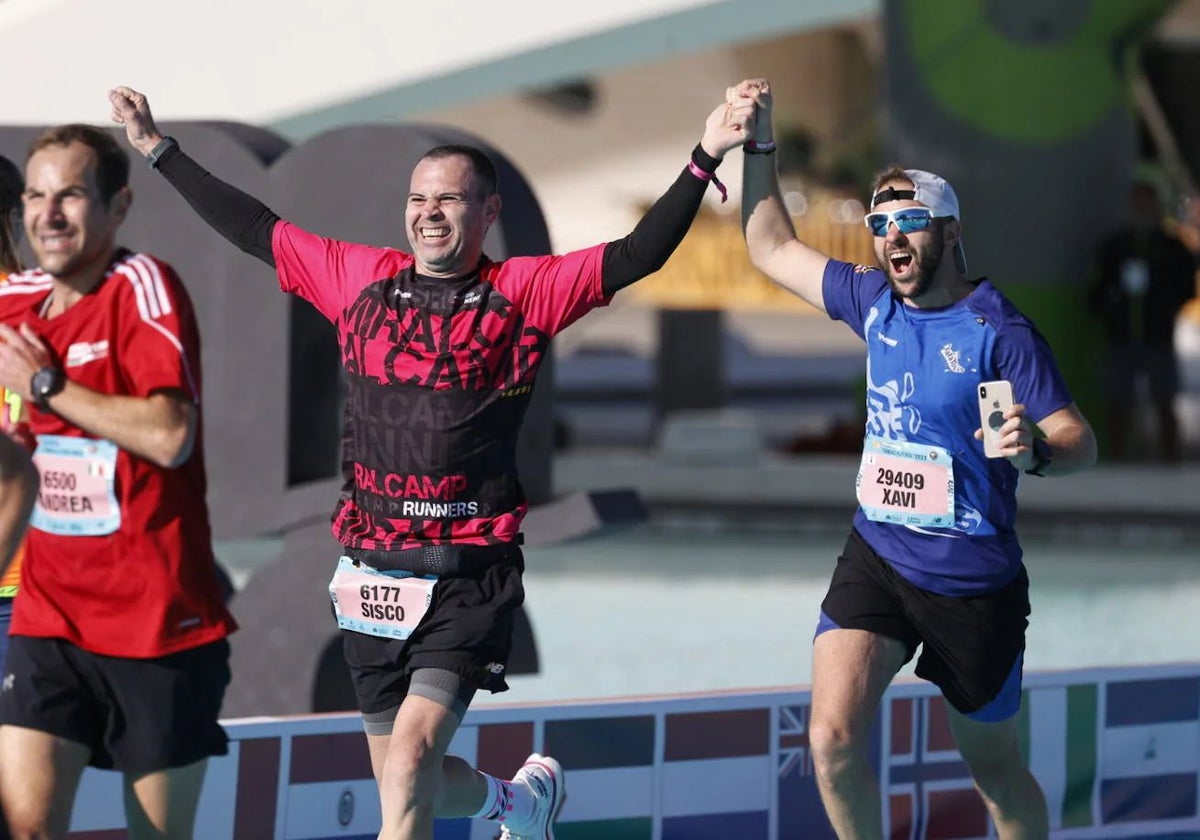 Corredores, satisfechos tras cruzar la línea de meta del Maratón de Valencia.