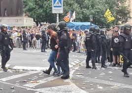 Un aficionado es retenido por la policía, con los grilletes puestos, tras la tensión en la salida de los aficionados que asistieron al partido del Valencia contra el Girona.