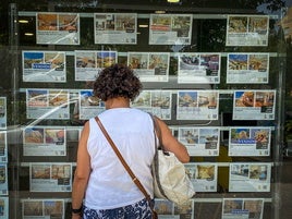 Una mujer mirando pisos en un inmobiliaria.