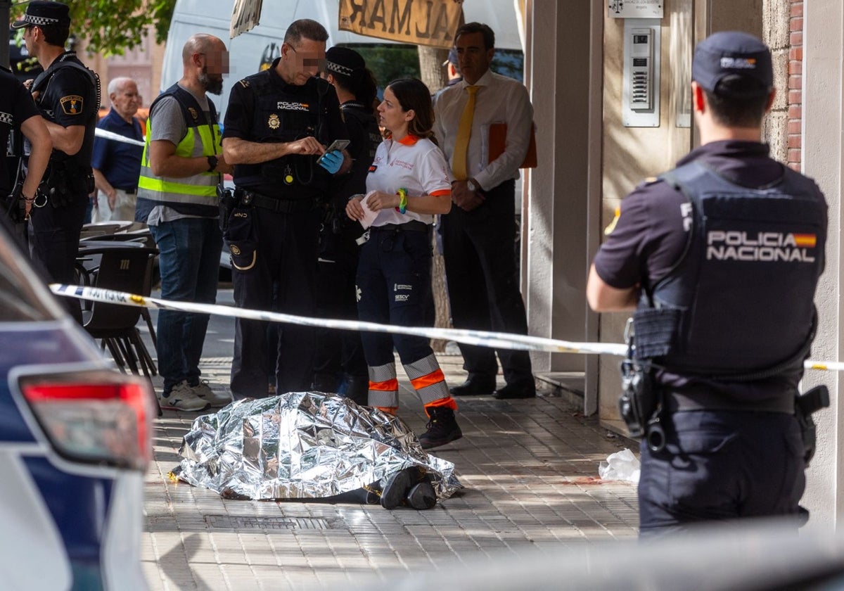 Varios policías y una sanitaria junto al cadáver de la víctima.