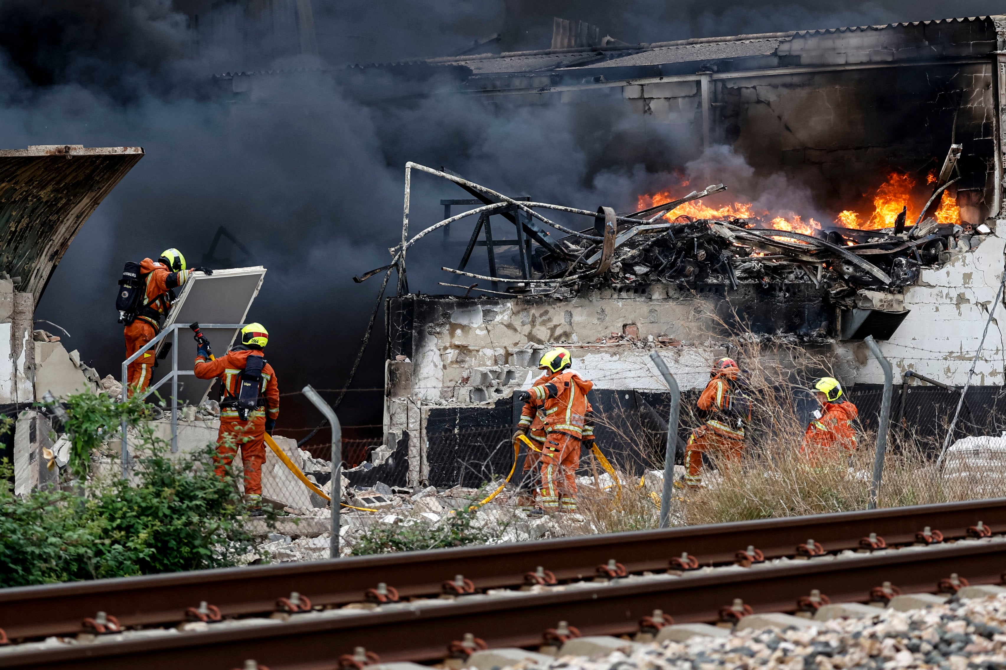 Los bomberos, durante la extinción del incendio que afectó a la fábrica de Cecotec en Sollana.