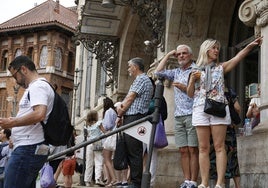 Un grupo de turistas se agolpan para entrar en el edificio.