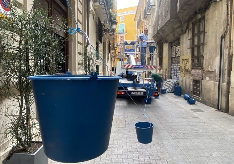 Montaje de los cubos de agua que decoran la Cabalgata del Convite, en la calle Cabillers.