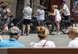 Varios turistas recorren la ciudad de Valencia en bicicleta.