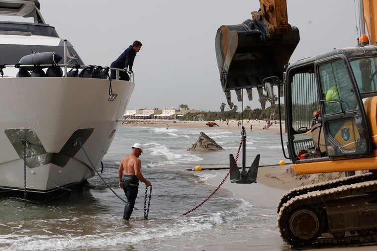 Excavadora, cable y operarios, en el segundo intento frustrado para desencallar el yate.