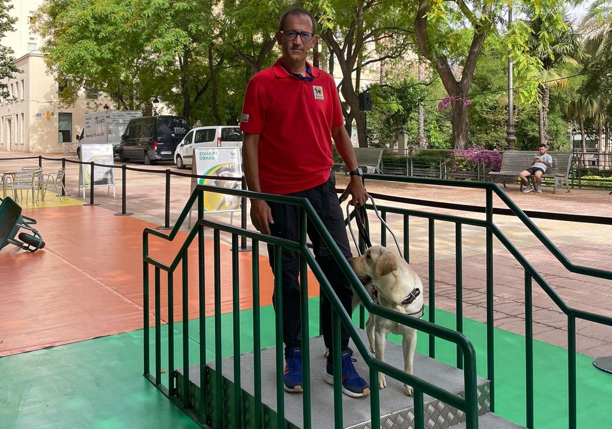 Uno de los perros guía ayudando a bajar las escaleras con uno de los adiestradors.