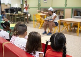 Algunos niños escuchando cómo les cuentan un cuento, en una imagen de archivo.