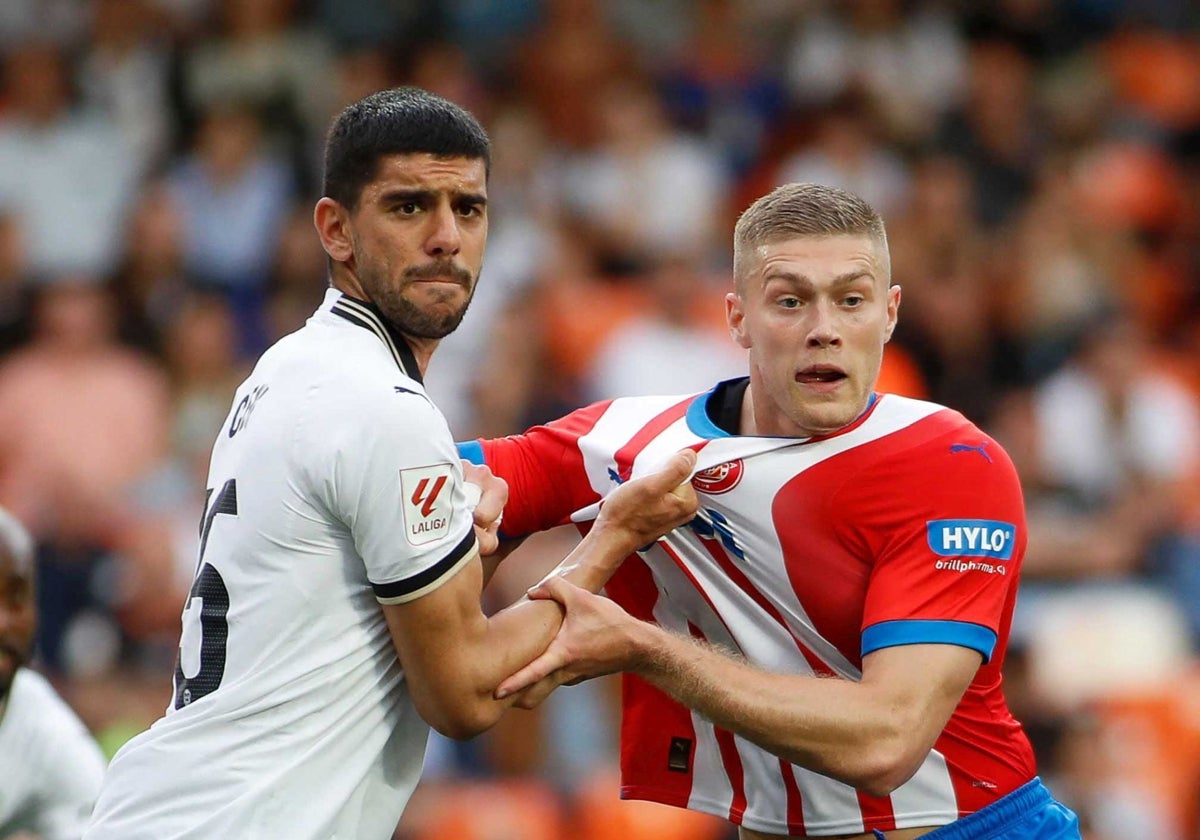 Cenk sujeta a Dovbyk durante un partido.