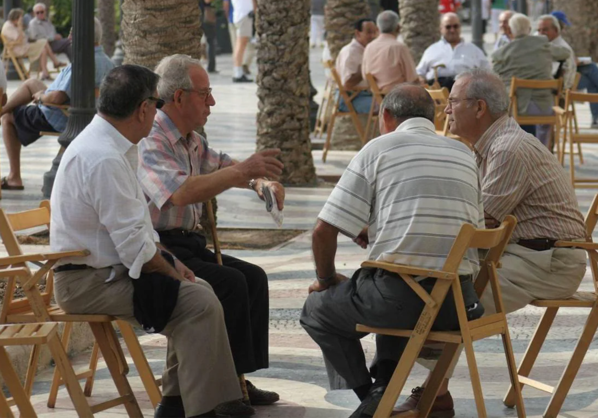 Un grupo de jubilados charlan en un parque.