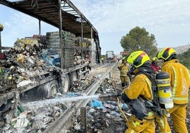 Los bomberos extinguiendo el fuego en el camión.