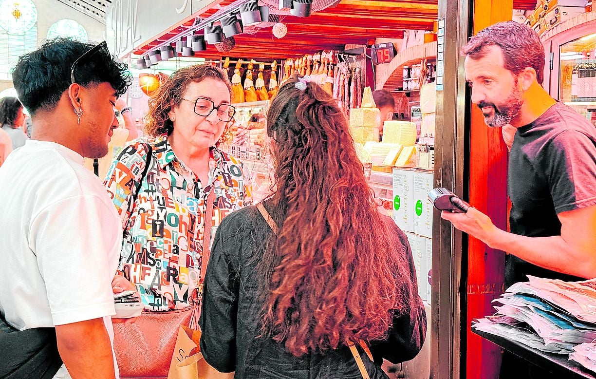 Paco Solaz, atendiendo a varios clientes en la parada del Mercado Central.