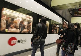 Un metro en la estación mientras pasajeros esperan para subir.