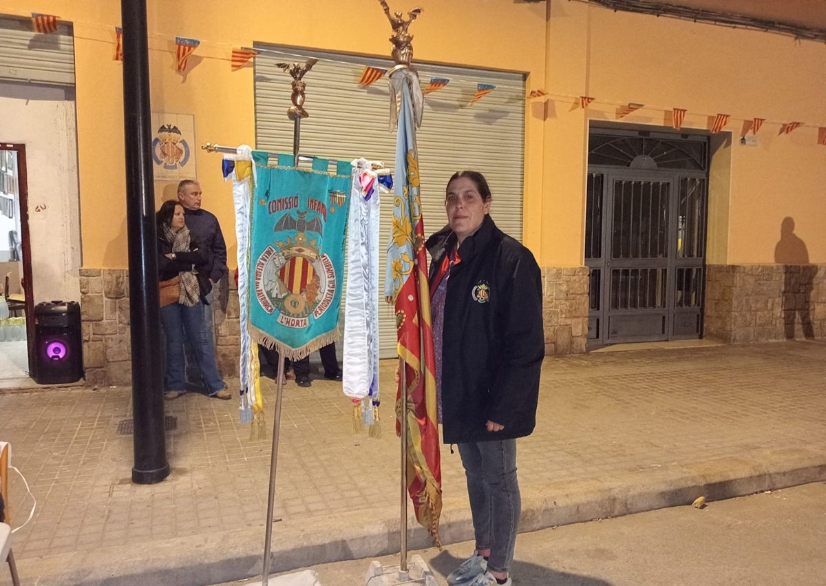 Imagen secundaria 1 - Los falleros de Alfara del Patriarca, en un acto de la comisión y Raquel Báguena, presidenta, con el estandarte, en la puerta del casal.