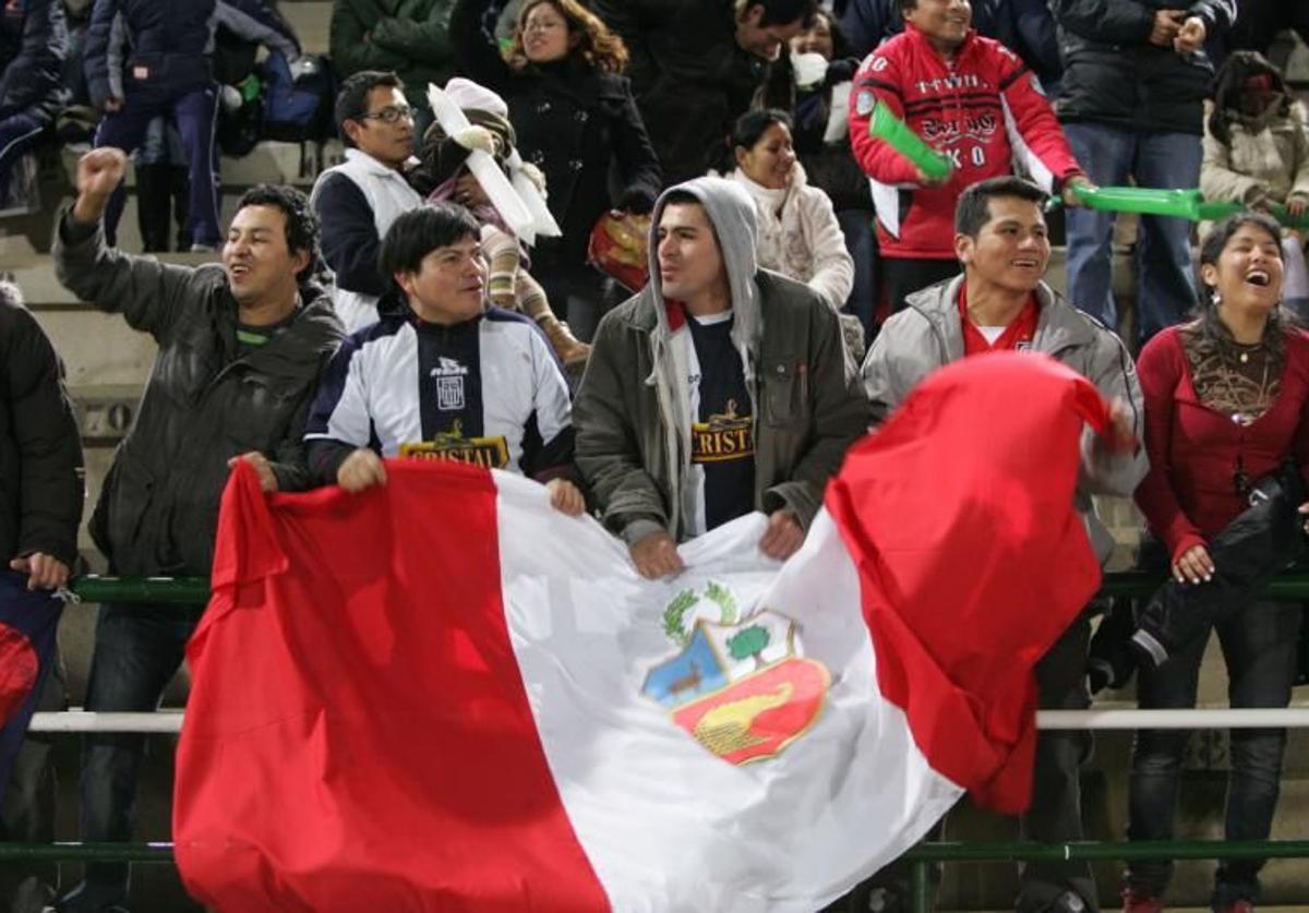 Aficionados con la bandera de Perú.