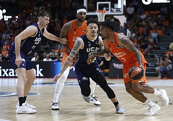 Jones, con el balón, ataca la defensa de Radebaugh.
