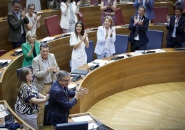 Miembros del Consell aplauden tras la aprobación de la ley en Les Corts.