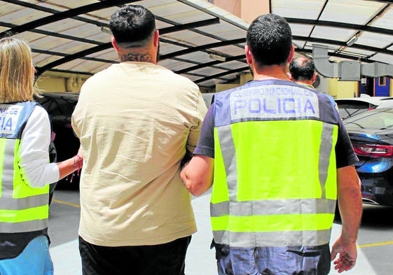 El detenido, junto a dos agentes, después de entregarse en la central de Policía Local.