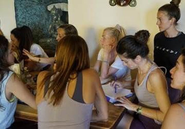 Alumnas toman nota en una clase de yoga.