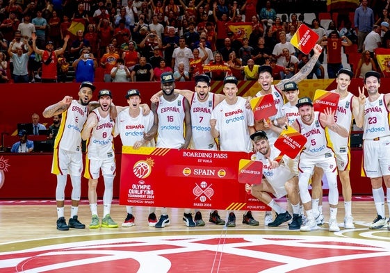 Los jugadores de España posan con el cartel de clasificados para los Juegos de París en el parquet de la Fonteta.