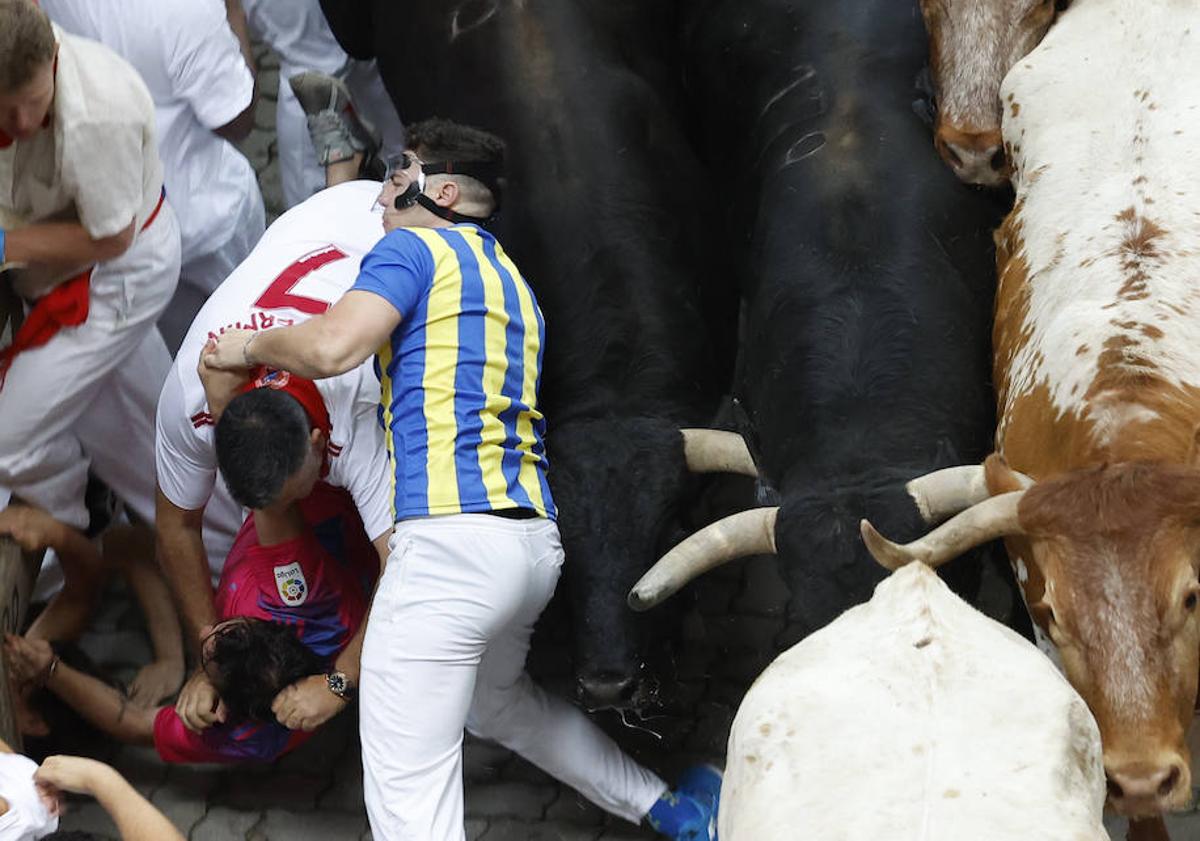 Imagen principal - Sentir el pitón en la barriga y vivir para contarlo: la fortuna del mozo con la &#039;máscara de Mbappé&#039; en el encierro de Sanfermines