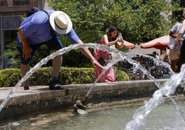 Varias personas se refrescan en una fuente de Valencia.