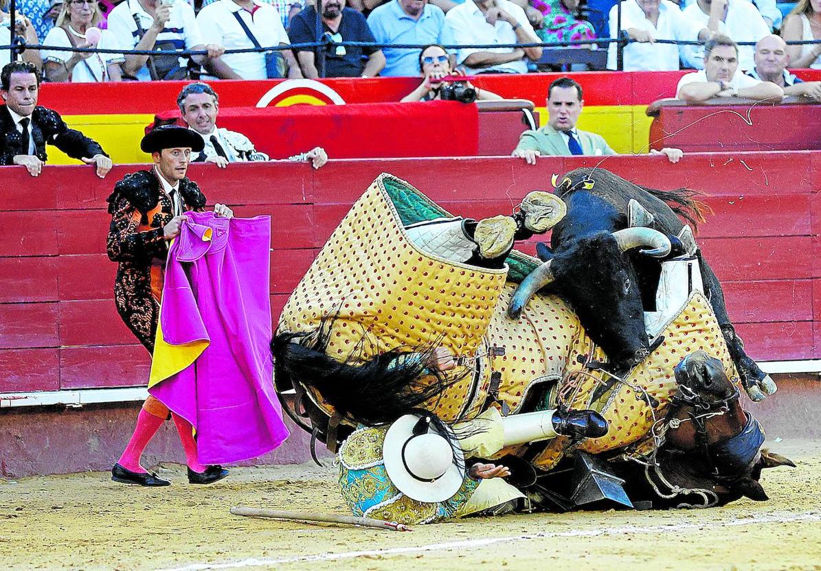 Uno de los toros derriba al caballo y al picador.