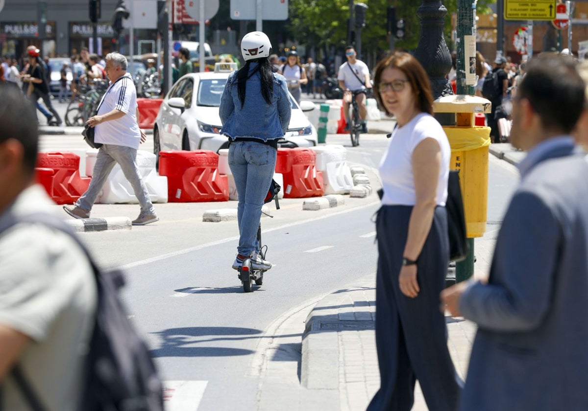 Una joven circula con un patinete por una calle del centro de Valencia, en una imagen de archivo.