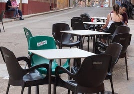 Sillas con publicidad de cerveza en la terraza de un bar.