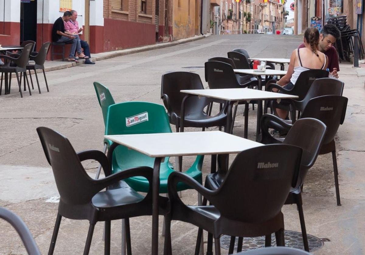 Sillas con publicidad de cerveza en la terraza de un bar.