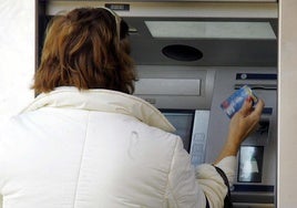 Una mujer sacando dinero de un cajero en una imagen de archivo.