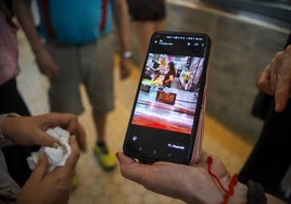 Una vendedora del Mercado Central muestra los 36,5 grados que se ha alcanzado un día este verano en el recinto.