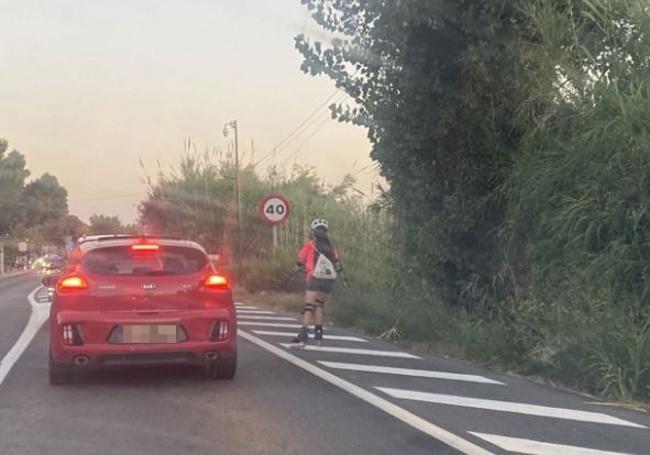 Una patinadora, por el arcén de la CV.500.