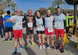 Fermín Cacho posa con un grupo de corredores en una carrera popular.