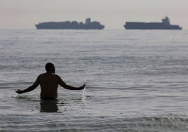 Un bañista en las playas del sur de Valencia afectadas por el chapapote.