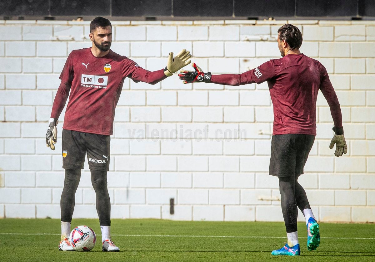 Mamardashvili le choca la mano a Dimitrievski en un entrenamiento del Valencia