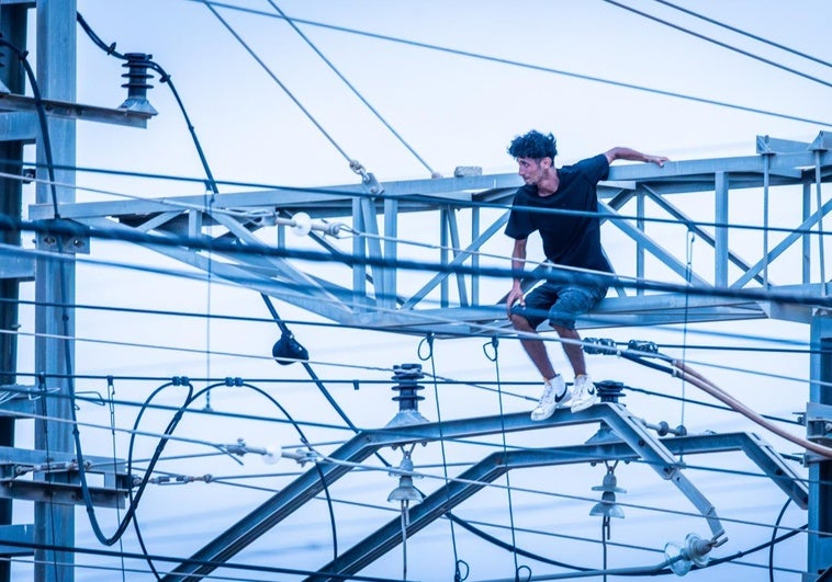 El joven encima de la estructura de la catenaria.