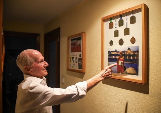 Vicente Peralta, junto a los cuadros donde acumula medallas, dorsales, imágenes y recuerdos.