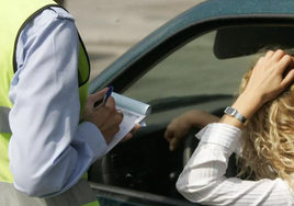 Un agente multa a una conductora, en una imagen de archivo.