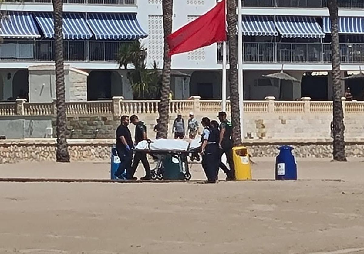 Agentes se llevan el cuerpo del hombre ahogado este martes en la playa de Cullera.