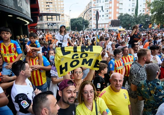 Aficionados muestran carteles contra Lim a las puertas de Mestalla.