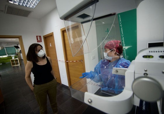 Una sanitaria y una paciente en una prueba de detección del cáncer.