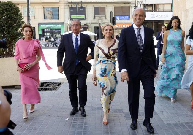 Francisco Camps e Isabel Bas llegan a la boda de Natalia Santos Yanes el pasado mes de junio acompañados de Vicente Garrido y Begoña Mortes, las dos vestidas con diseños de Lila Albanozzo.