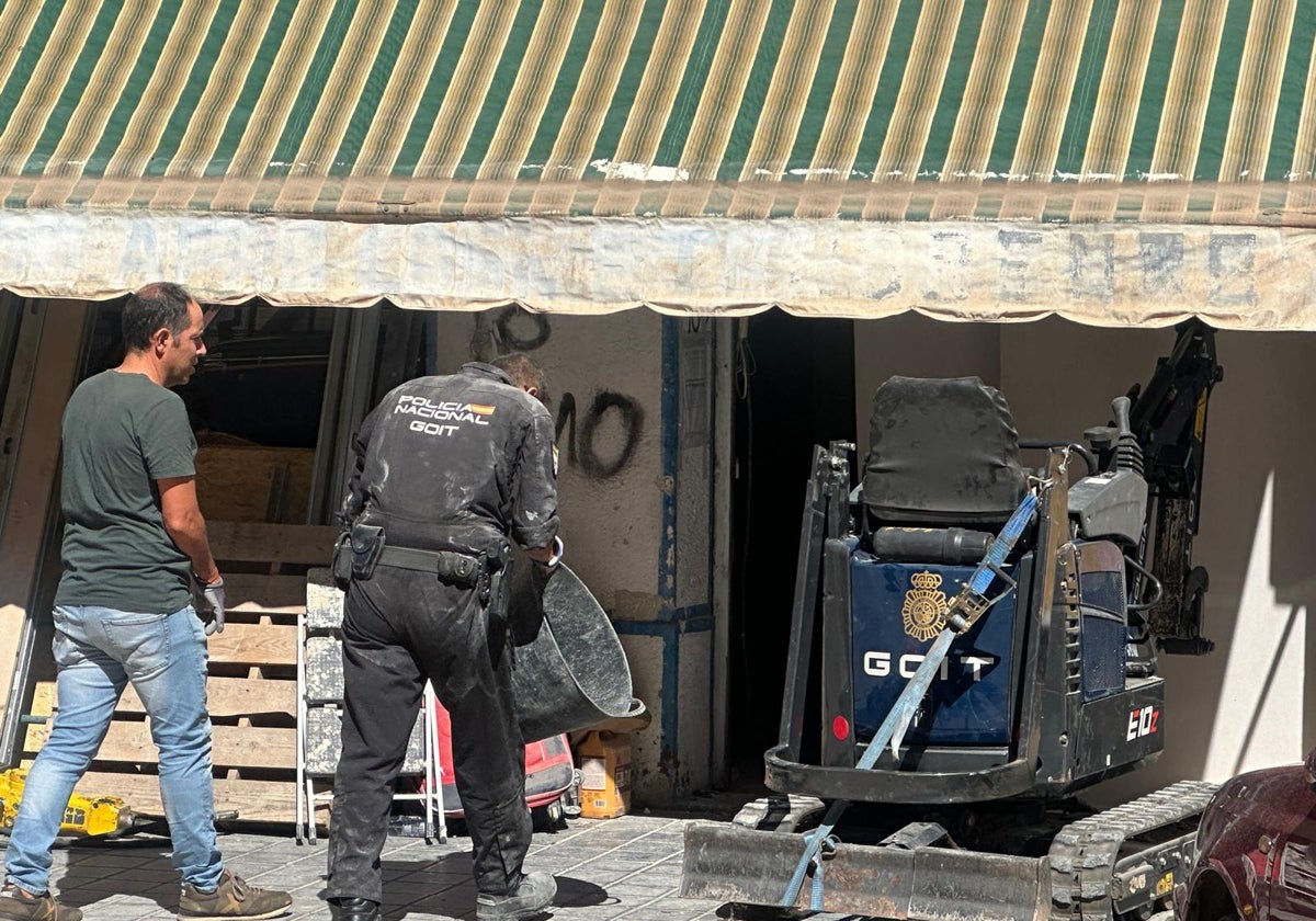 Dos policías en la puerta de la planta baja donde buscaron restos humanos.