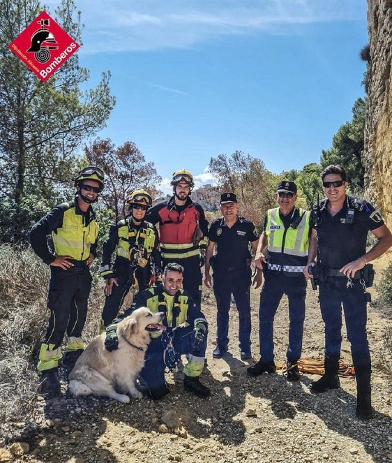 El perro con los bomberos y los agentes de policía, tras el rescate.