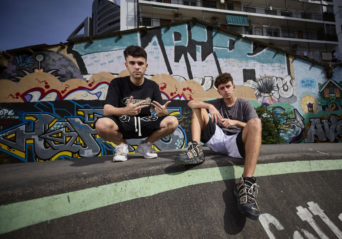 Segrelles y Alek, raperos de competición nacional, sentados en una pista de patinaje junto a unos grafitis, en Valencia.