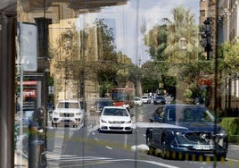 Coches circulando ante una parada de autobús vacía en el centro de Valencia esta mañana