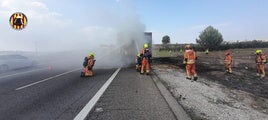 Bomberos apagando las llamas del camión.